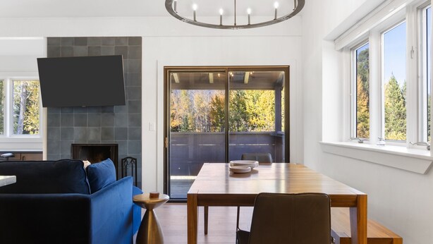 Ein modernes Wohnzimmer mit Kamin, Esstisch und einer Couch.