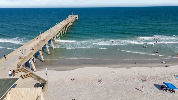 A pier extending into the ocean with people walking and sitting on it. - LinkedOUT #171 – 3 BD Dog Friendly Greensboro St Duplex Steps from the beach! (Wrightsville Beach)