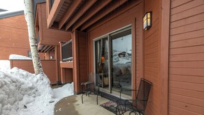 A wooden building with a glass door and a metal chair outside. - Alpine Comfort Just Steps from the Slopes – Timber Run 306! (Steamboat Springs)