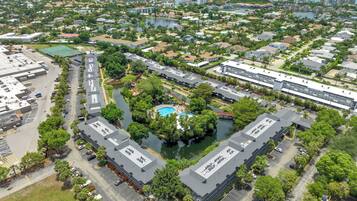 A residential area with a large building complex, a swimming pool, and a marina.