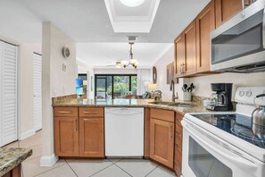 A kitchen with wooden cabinets, a dishwasher, a stove, and a microwave.