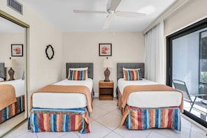 A hotel room with two beds, a ceiling fan, a large window, and a view of the outdoors. - C-123 -First Floor With Resort Views (Naples)