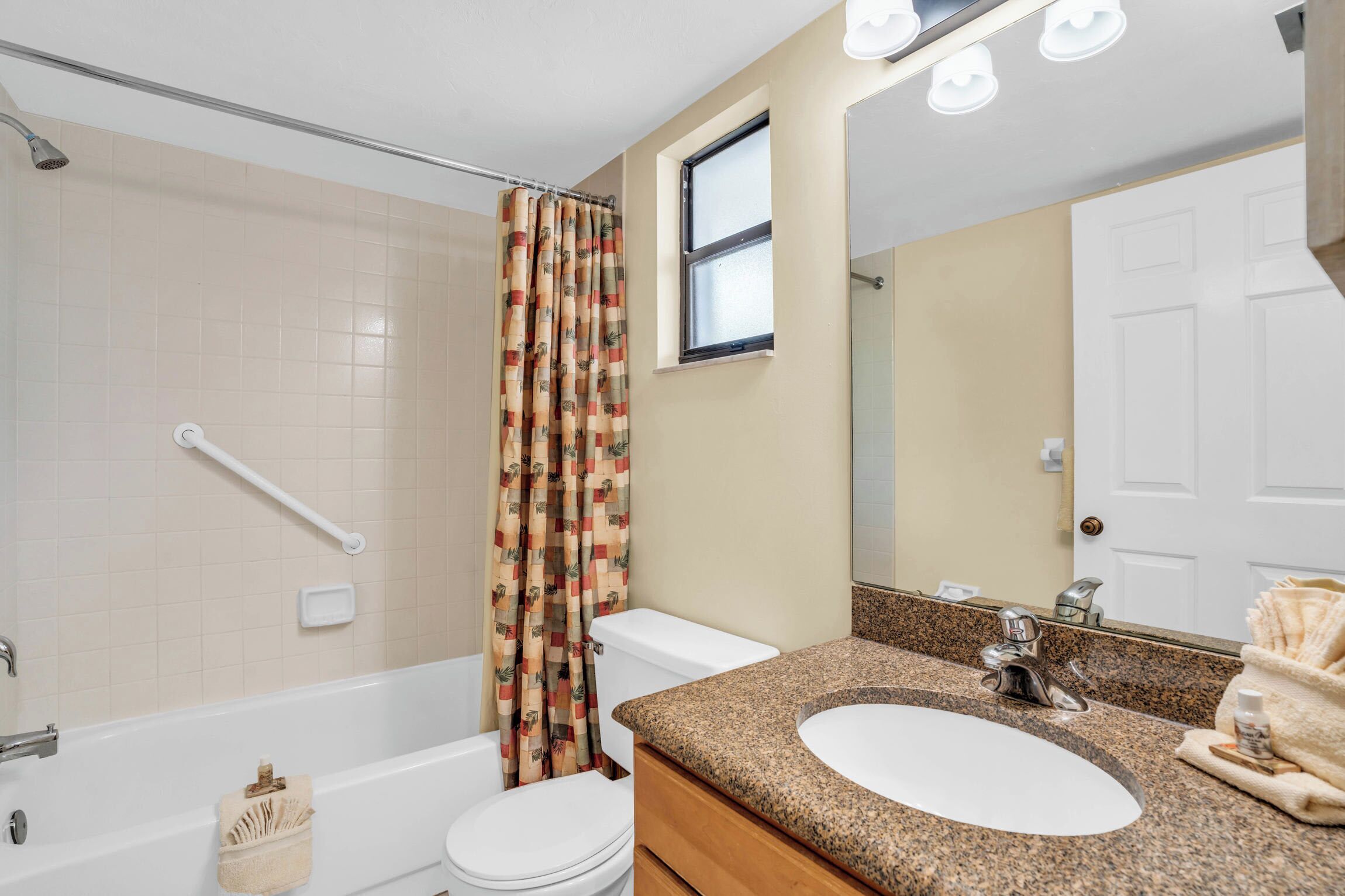 A bathroom with a bathtub, toilet, and sink.