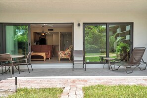 A patio area with a table and chairs, a cushioned sofa, and a lounge chair. - I-151 - First Floor With Resort View & Sleeps 4 (Naples)