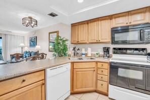 A modern kitchen with wooden cabinets, a dishwasher, a stove, and a microwave.