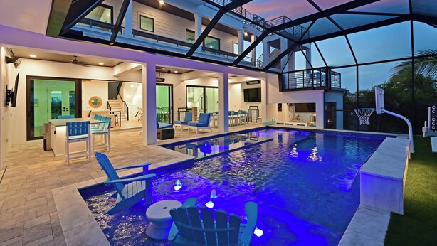 Ein moderner Poolbereich im Innenbereich mit Glasdecke, mehreren Sitzbereichen und einer sichtbaren Treppe, die zu einer oberen Ebene führt.