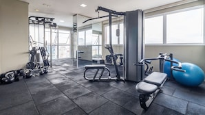 Una palestra con attrezzature per esercizi, una panca e un'ampia palla da ginnastica blu.