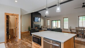 Een moderne keuken met een centraal eiland, inbouwapparatuur en een open haard.