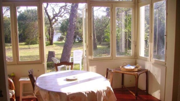 A room with a round table, chairs, and a small table with a basket. - Maison D'été Plage a Pied Oleron (Saint-Pierre-d'Oléron)