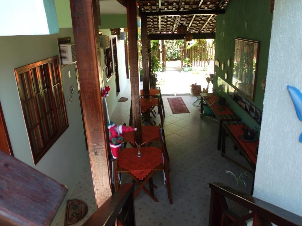 Un espacio de comedor al aire libre con techo, muebles de madera y vista a la calle.