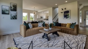 A modern living room with a brown leather sofa, a wooden coffee table, and a patterned rug. - Panoramic Paradise 4 Bedroom Cabin by RedAwning (Sevierville)