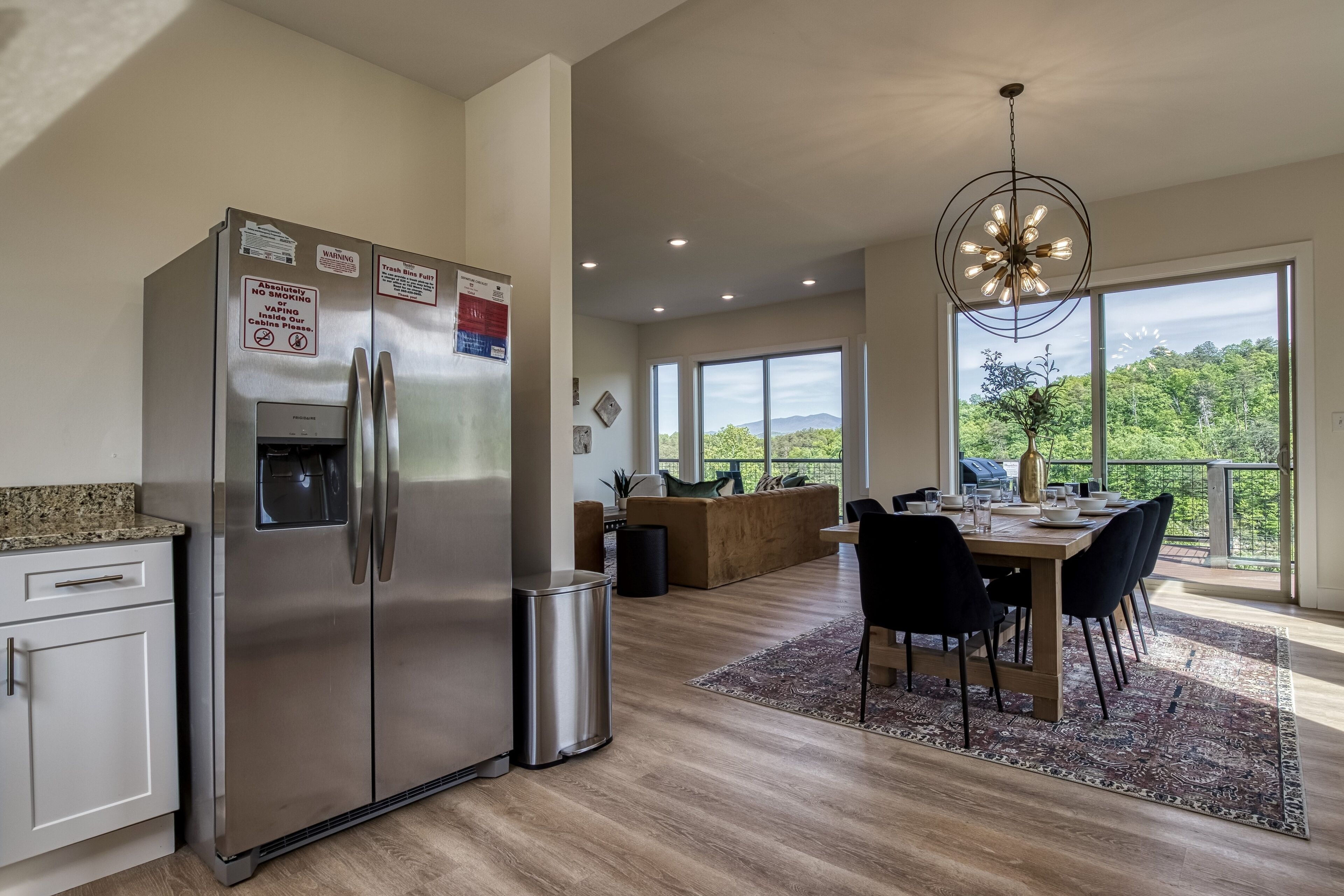 Una cocina moderna con electrodomésticos de acero inoxidable, un comedor con un ventanal y vistas a zonas verdes.