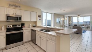 A modern kitchen with white cabinetry, a built-in microwave, and a dishwasher. - Terrace At Pelican Beach 0907 3 Bedroom Condo (Destin)