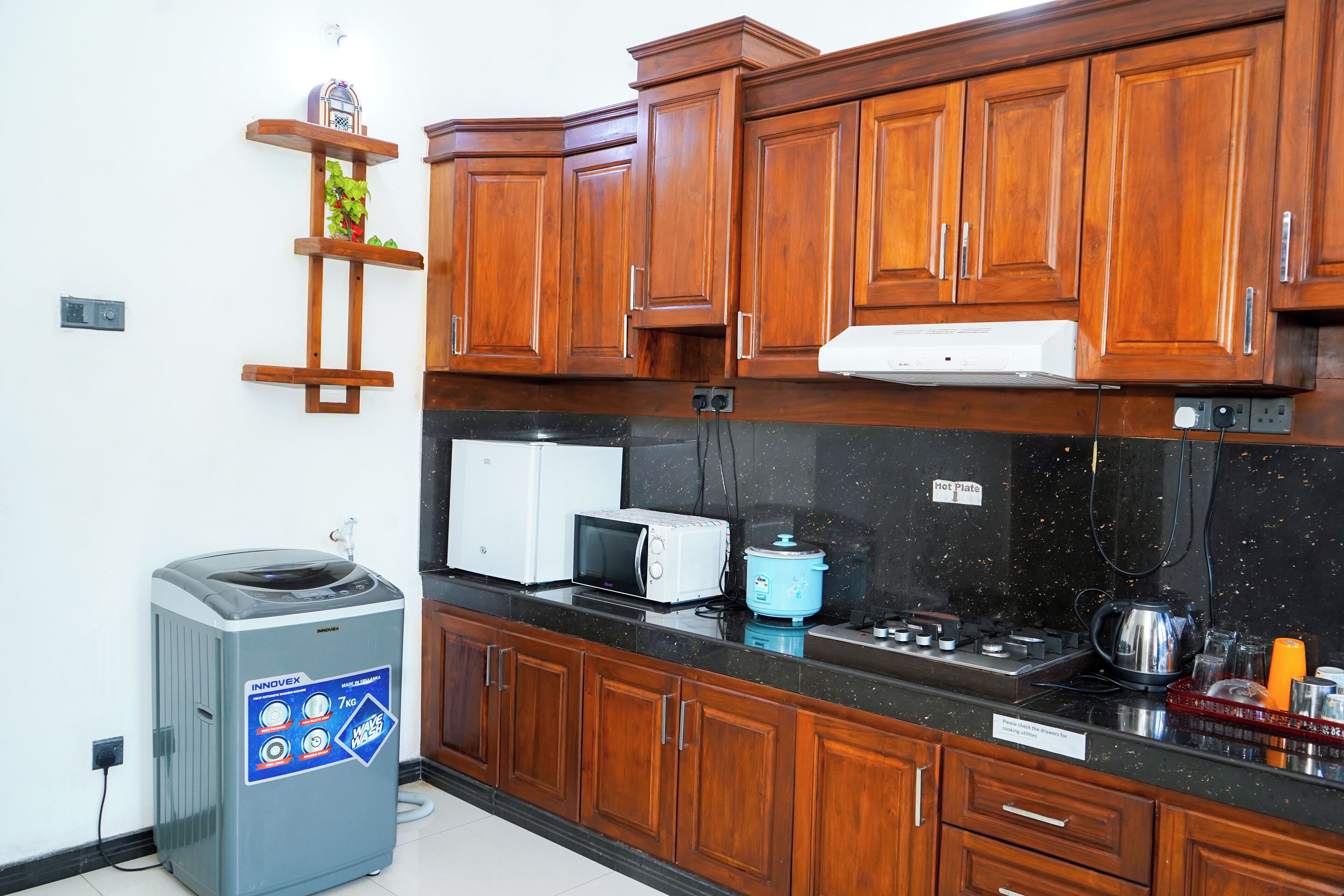 A kitchen with wooden cabinets, a microwave, a toaster, and a water dispenser.