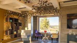 A modern living room with a stone wall, a large window, and a view of the outdoors.