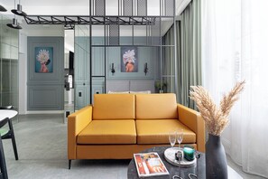 Suite estudio Deluxe | Zona de estar | Una televisión de pantalla plana