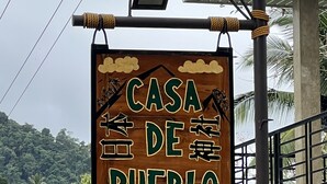 A sign for 'Casa de Pueblo Japanese Shrimp' with a wooden background and green lettering.