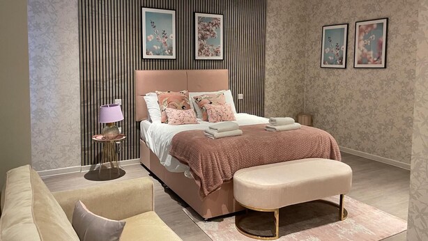 A modern bedroom with a large bed, a bedside table, a lamp, and a bench. - 
Cosy & Modern 1 Bed Apartment (Orpington)