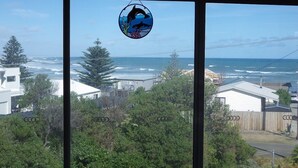 A view through a window with a dolphin logo, a coastal landscape, and residential buildings.