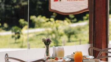 A table with a sign reading "Le Bistro Restaurant" and a view of greenery outside.