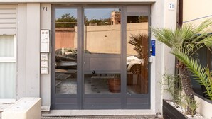 A building entrance with a grey door, numbered 71, and a small blue sign on the right. - Santamaria Apartment by Wonderful Italy (Siracusa)