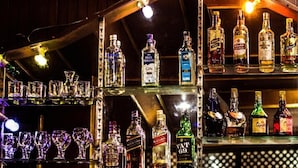 A bar with shelves of liquor bottles and glasses. - Hotel Kamal (Kathmandu)