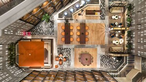 A spacious atrium with a central seating area, a reception desk, and a staircase.