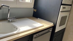 A kitchen with a sink, a window, a dishwasher, and a microwave.