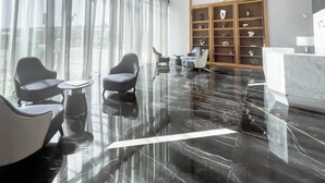 A modern lobby with a polished marble floor, contemporary seating, and a decorative shelving unit. - Luxury Skyline Studio | Pool and Stunning Views (Dubai)