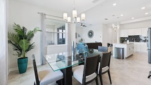 A modern kitchen with white cabinets, a black backsplash, and stainless steel appliances.
