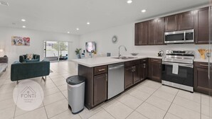 Una cocina moderna con armarios de madera oscura, electrodomésticos de acero inoxidable y una isla grande con un lavamanos.