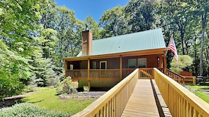 Eine Lodge mit einer Holzterrasse, die zu einem Gebäude mit grüner Dachbegrünung und einer amerikanischen Flagge führt.
