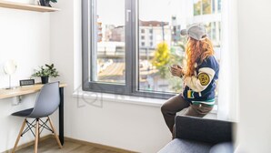 Een moderne kamer met een groot raam, een bureau, een stoel en een bank.