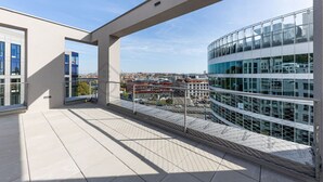 Een modern gebouw met een glazen gevel en een balkon met een metalen leuning.