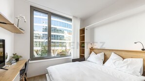 Een moderne hotelkamer met een groot bed, een bureau en een raam met uitzicht op de stad.
