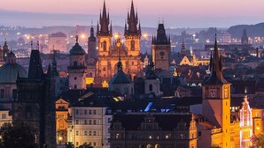Eine historische Stadtansicht mit markanter gotischer Architektur, darunter ein Dom mit zwei Türmen und einem Glockenturm.