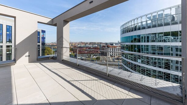 Ein modernes Gebäude mit Glasfassade und einem Balkon mit Metallgeländer.
