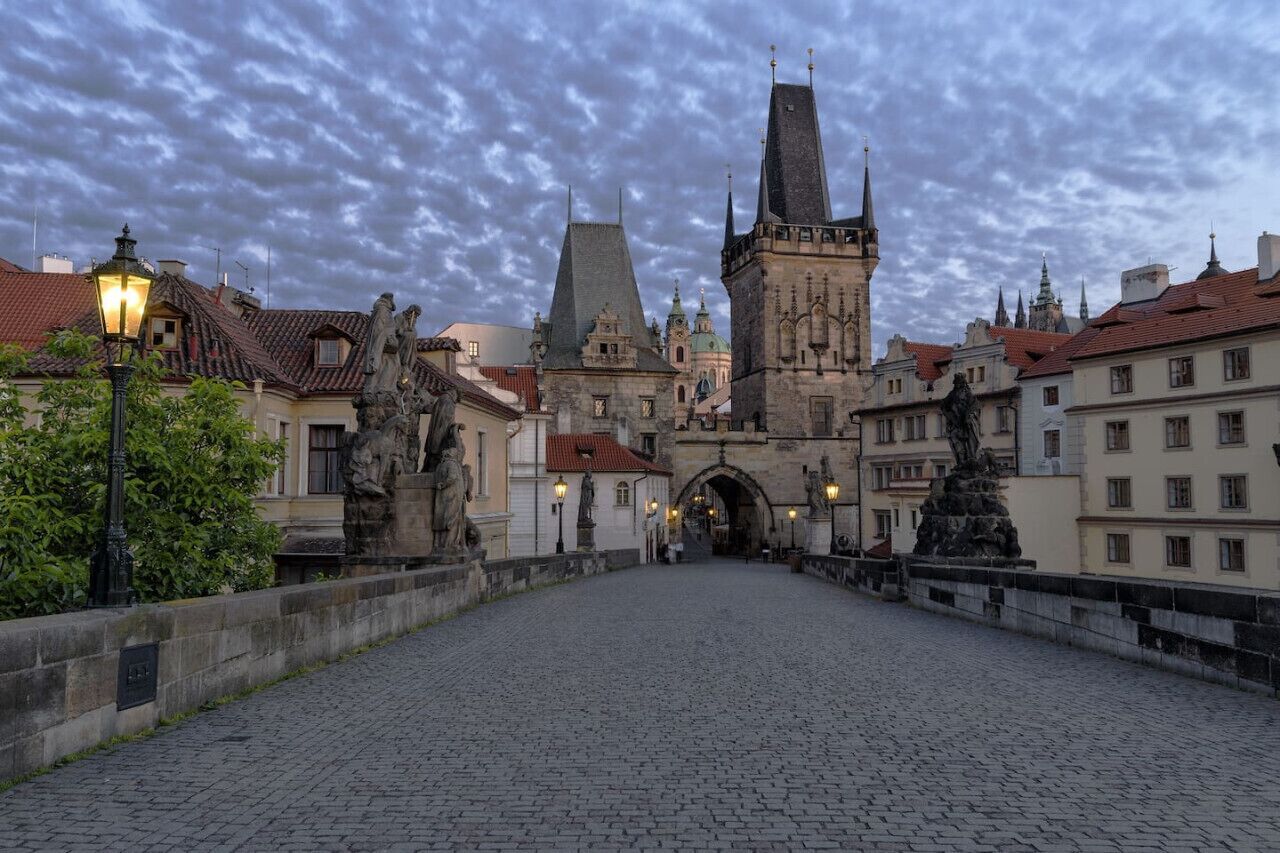 Eine gepflasterte Straße führt zu einem historischen Gebäude mit einem markanten Turm.