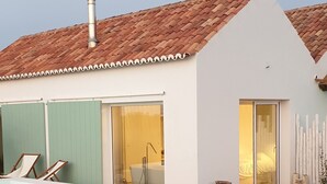 Ein modernes Haus mit Schwimmbad, einer Glastür zu einem Badezimmer und einer Holzterrasse.