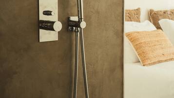 Une douche équipée d’un flexible, d’un panneau de commande et d’un porte-serviettes.