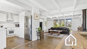 A modern kitchen with white cabinetry, a stainless steel refrigerator, and a built-in oven. - Blairgowrie Back Beach Holiday Escape (Blairgowrie)