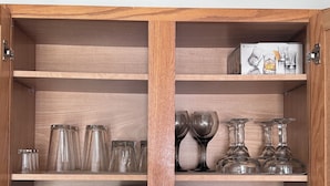 A wooden cabinet with glassware, plates, and mugs. - Cozy and Charming Amber Valley Haven in Fargo (Fargo)