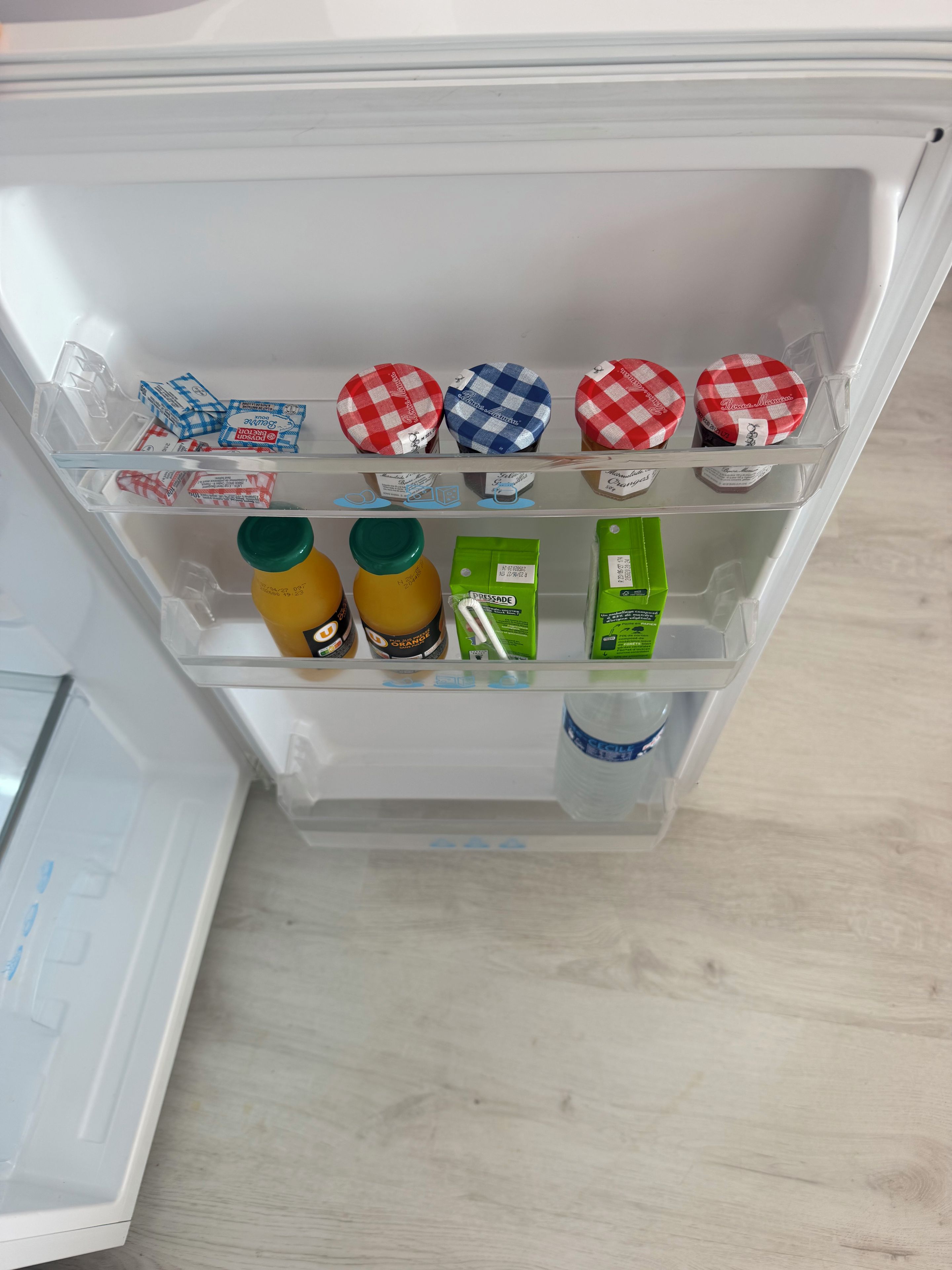 Un réfrigérateur doté de plusieurs étagères contenant divers aliments et récipients.