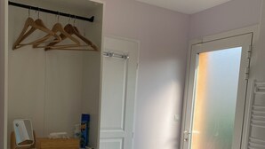 Een kleedkamer met houten kledinghangers, planken met opgevouwen handdoeken en een spiegel.