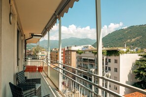 A balcony with a view of a cityscape and mountains. - Appartamento Romantico (Como)