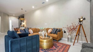 Una sala moderna con un conjunto de sofá, una mesa de centro y una lámpara de pie.