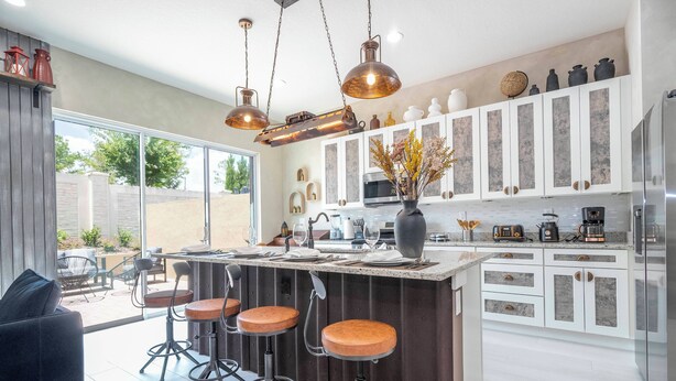 A modern kitchen with a central island, bar stools, and a dining area with a black sofa. - A Galaxy?s Edge Experience Awaits! 5 Min to Disney (Kissimmee)