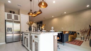 A modern kitchen with a central island, stainless steel appliances, and pendant lighting. - A Galaxy?s Edge Experience Awaits! 5 Min to Disney (Kissimmee)