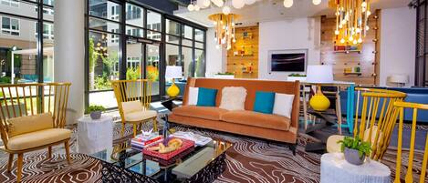 A modern living room with a brown sofa, yellow chairs, and a glass coffee table.