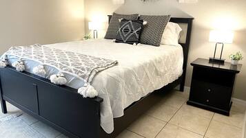 A bedroom with a bed, nightstands, and wall-mounted lights.
